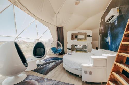 a bedroom with a bed and two chairs in a tent at Clear Sky Resorts - Grand Canyon - Unique Sky Domes in Valle