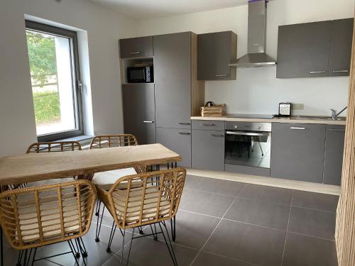 a kitchen with a wooden table and chairs at Les hauts de Meez in Dinant