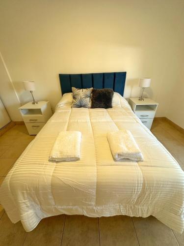 a large white bed with two nightstands and two lamps at Paramont Rosario 2 in Rosario de la Frontera