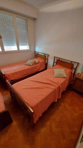 two twin beds in a room with two windows at Peatonal al Mar in Miramar