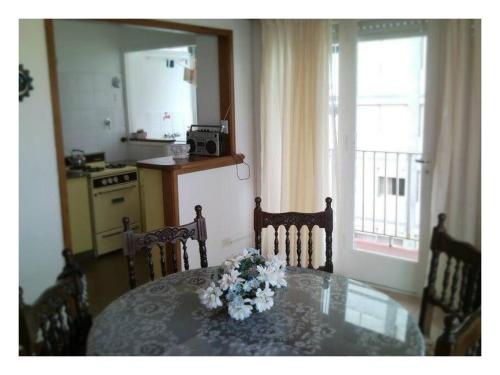 a dining room with a table with flowers on it at Peatonal al Mar in Miramar