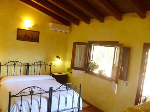 a bedroom with a bed and a window at Sa Stella E Monti in Marrùbiu