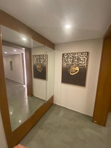 a room with two paintings on the wall and a hallway at Maison 7 in El Obour