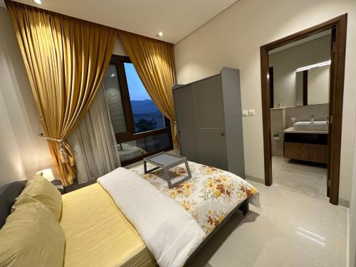 een slaapkamer met een bed en een badkamer met een wastafel bij Casa de Amor Sifa in As Sīfah