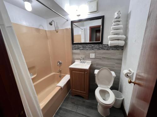 a bathroom with a tub and a toilet and a sink at Budget Inn Marinette in Marinette