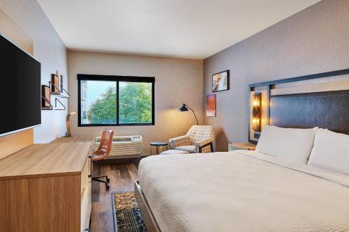 a hotel room with a bed and a desk and a window at Four Points by Sheraton Salt Lake City Airport in Salt Lake City