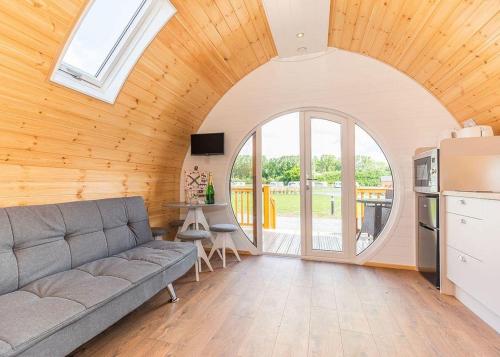 a living room with a couch and an arched window at High Farm Holiday Park in Beverley