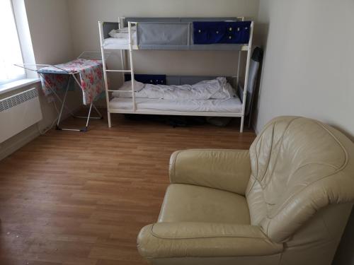 uma sala de estar com uma cadeira e uma cama em Mielno, Spokojna 2A - blisko plaży em Mielno