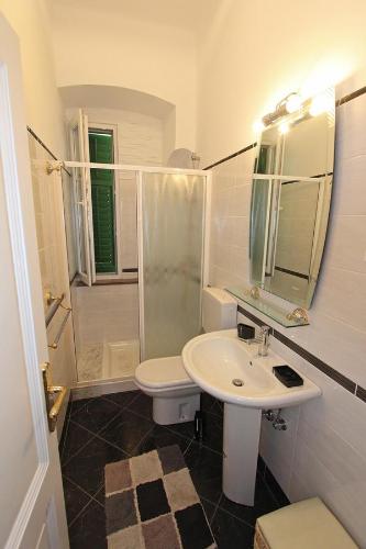 a white bathroom with a sink and a shower at Villa Istria in Lovran