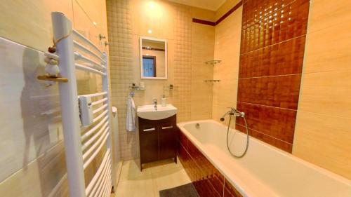 a bathroom with a sink and a tub and a shower at Air conditioned, 2 room Apartment, New City in Koliba