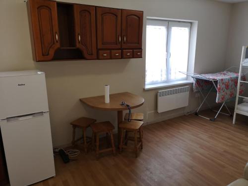 uma pequena cozinha com uma mesa e um frigorífico em Mielno, Spokojna 2A - blisko plaży em Mielno