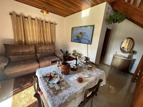 uma sala de estar com uma mesa e um sofá em Raio de Sol na Montanha em Campos do Jordão