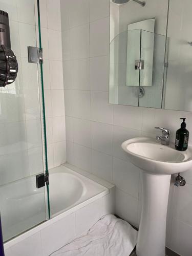 a white bathroom with a sink and a bath tub at Paddington house beautiful 2 bedroom terrace in Sydney