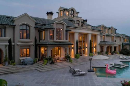 a large house with a swimming pool in front of it at Lakeside Grande Villa in Alexander City