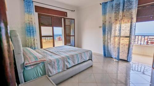 a bedroom with a bed and a view of the ocean at Oued Laou Apartment in Oued Laou