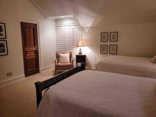 a bedroom with two beds and a chair and a lamp at Lakeside Grande Villa in Alexander City