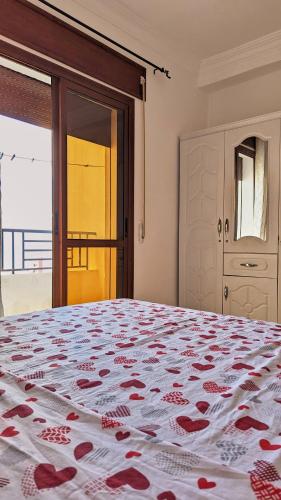 a bedroom with a large bed with red roses on it at Oued Laou Apartment in Oued Laou