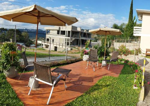 a group of chairs and umbrellas on a patio at Pousada Bella Vista - Vale dos Vinhedos in Bento Gonçalves