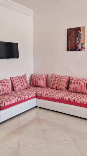 a couch with red pillows sitting in a room at Oued Laou Apartment in Oued Laou