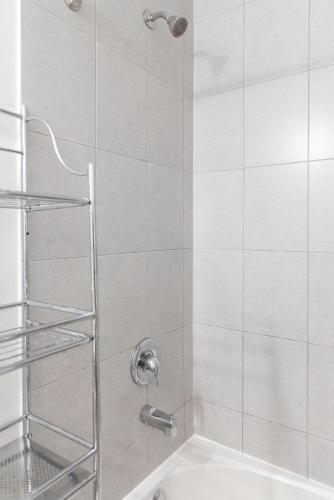 a shower with a shower head in a bathroom at Beautiful Townhouse Near Yorkdale Mall, Wilson Subway in Toronto