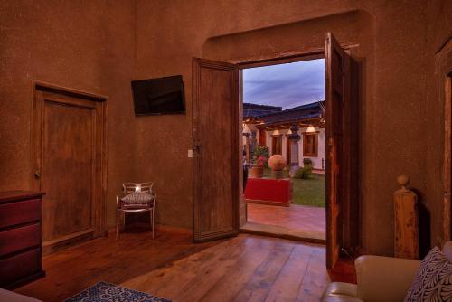 eine offene Tür zu einem Wohnzimmer mit einem Stuhl in der Unterkunft HOTEL LA CASA DE DON VASCO in Pátzcuaro