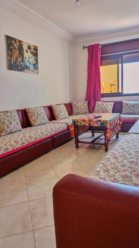 a living room with a red couch and a table at Oued Laou Apartment in Oued Laou