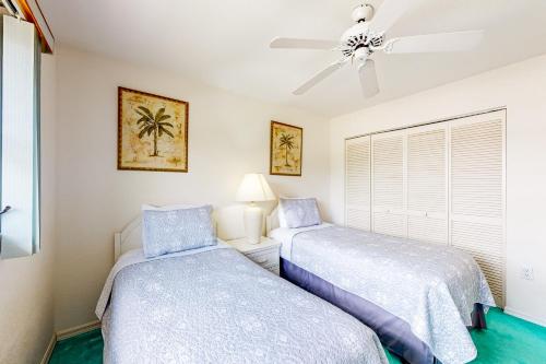 2 camas num quarto com uma ventoinha de tecto em Koala Bungalow em Port Charlotte