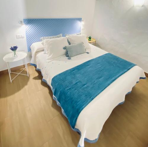 Schlafzimmer mit einem großen Bett mit blauem Kopfteil in der Unterkunft Casa Gercko 2 in Yaiza