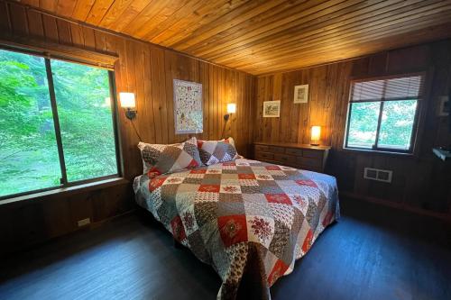 1 dormitorio con 1 cama en una habitación de madera con ventanas en Nana and Papa's, en Joseph