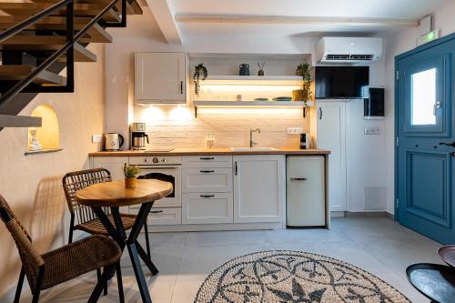a kitchen with white cabinets and a table and a sink at Mosaic Luxury Home in Rhodes Town
