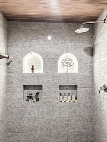 a bathroom with a shower with three windows at Mandevilla Canggu in Canggu