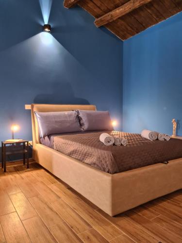 Cama en habitación con pared azul en Eco&Narciso apartment, en Monreale