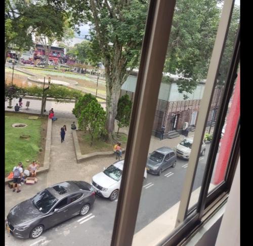- une vue depuis la fenêtre des voitures garées dans une rue dans l'établissement Hotel Milán, à Pereira