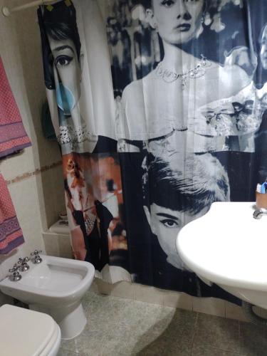 een badkamer met een douchegordijn, een toilet en een wastafel bij Loft Quilmes in Quilmes
