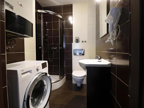 W łazience znajduje się pralka i umywalka. w obiekcie Sopot Marina Beach Suites w mieście Sopot