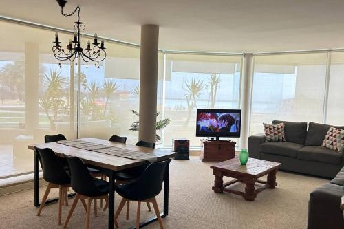 a living room with a table and a couch at Departamento San Alfonso del Mar, primer piso in Algarrobo