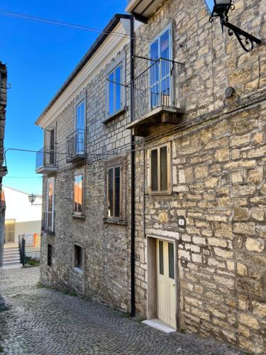 a stone building with a door and a balcony at Casa Acquaviva in Acquaviva Collecroce