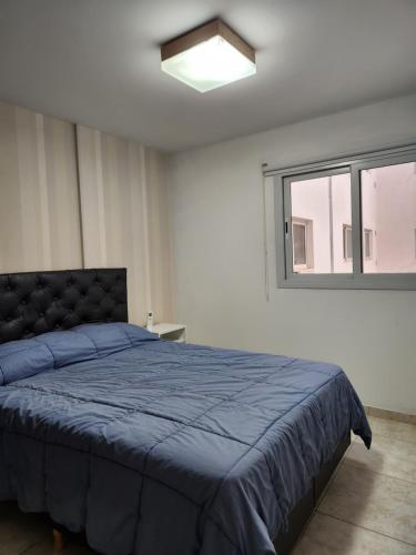 a bedroom with a blue bed and a window at Altos de colon in Cordoba