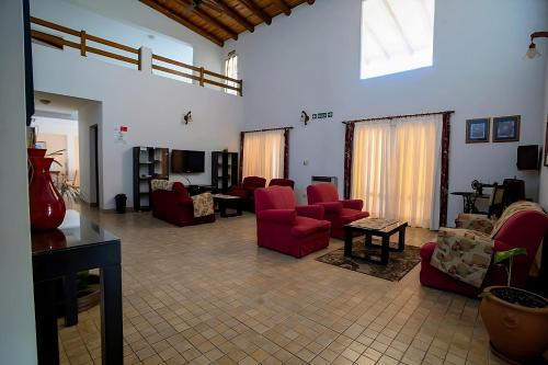 a large living room with red chairs and a table at Piedras del Lago in Federación
