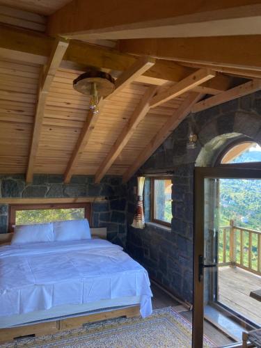 a bedroom with a bed and a stone wall at AXÂRA VİLLA SUİT in Pazar