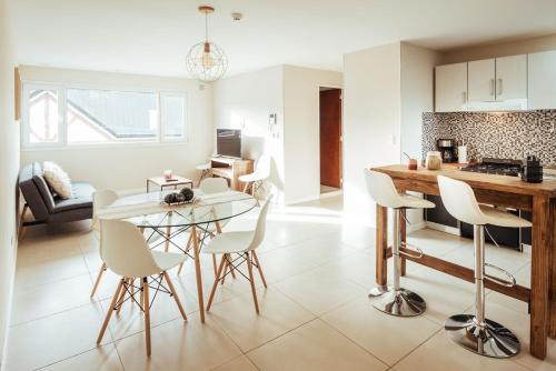 a kitchen and living room with a table and chairs at Gray Fox Apartments San Martin in Ushuaia