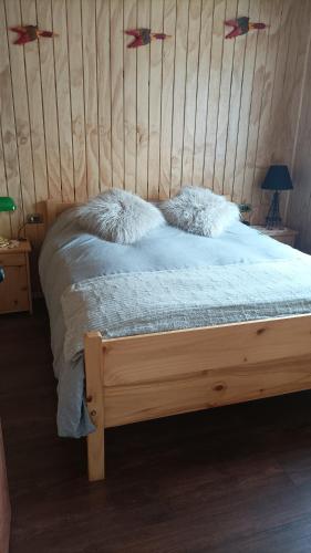 Una cama con sábanas blancas y almohadas. en Cabaña los pajaritos de frutillar en Frutillar