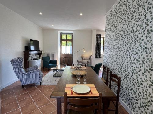 un salon avec une table et des chaises en bois dans l'établissement Évasion champêtre avec golf, terrasse et confort tout inclus à Lavault-Sainte-Anne - FR-1-489-438, à Lavault-Sainte-Anne