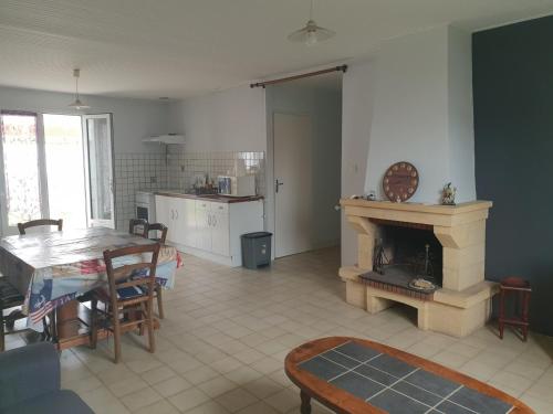 un salon avec une table et une cheminée dans l'établissement Maison agréable à 300m de la plage avec cour et TV, 3 chambres, pour 6 personnes, La Tranche-sur-Mer - FR-1-476-200, à La Tranche-sur-Mer