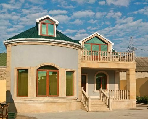 ein Haus mit einem grünen Dach und einem Balkon in der Unterkunft Gilavar 3 bedrooms in Cǝnubi