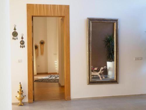 Villa Emraulde في مراكش: مرآة معلقة على جدار بجوار المدخل