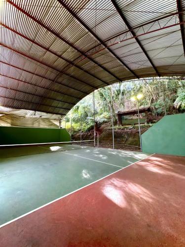 an indoor tennis court with a large roof at Natur Hotel - 700m da Rua Coberta in Gramado