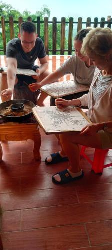 a group of people sitting at a table writing on paper at Hmong Eco Villas in Sa Pa