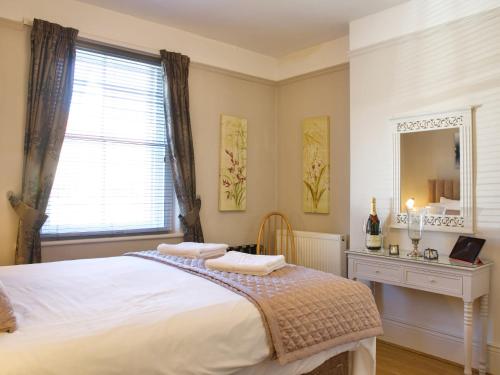 a bedroom with a large bed and a window at Quince Cottage - 25625 in Corbridge