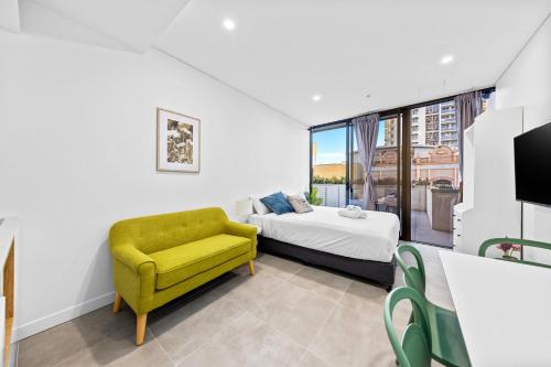 a bedroom with a bed and a yellow chair at Arthur Hotel Bondi Junction no reception and house keeping no sofa bed in Sydney
